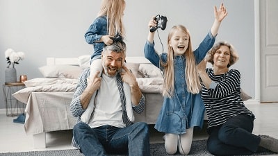 A família está se divertindo jogando videogame juntos.